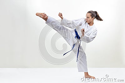 In karategi, a sportswoman strikes a kick Stock Photo