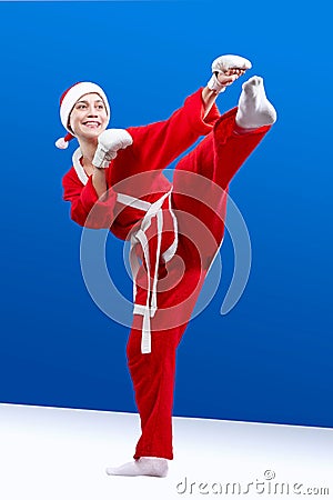 Karateka in the suit of Santa Claus hits a kick leg Stock Photo