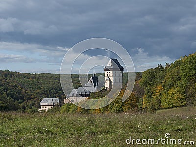 Karlstejn gothic state castle near Prague, the most famous castle in Czech Republic with grass meadow and autumn colored Stock Photo