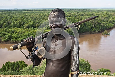 Man from the Caro tribe with an old rifle. Ethiopia, Omo Valley Editorial Stock Photo