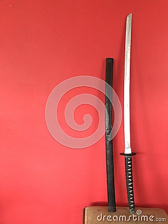 katana made of wood on a red background Stock Photo