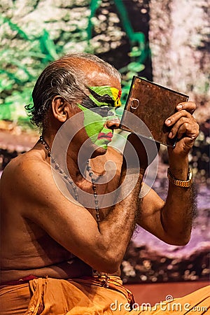 Kathakali exponent preparing for performance by applying face make-up. Kathakali is the classical dance form of Kerala Editorial Stock Photo