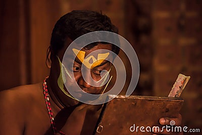 Kathakali exponent preparing for performance by applying face make-up Editorial Stock Photo