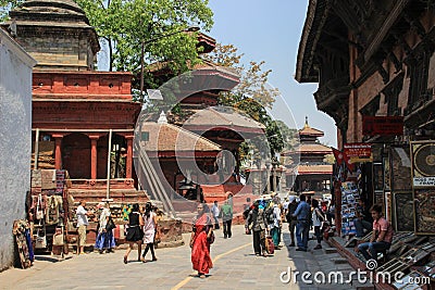 Kathmandu`s main attraction is Durbar Square with the royal palace, architecture, carved wooden figures and people walking. UNES Editorial Stock Photo