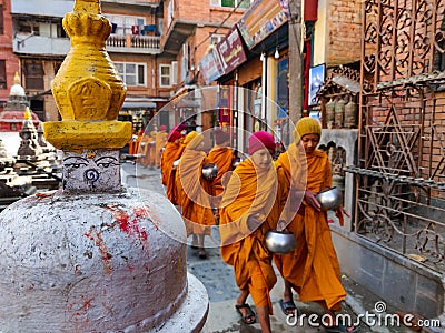 Kathmandu, Nepal - December 17 2019: Young Buddhist monk circulating a Buddhist gompa. Selective Focus - focus on gompa Editorial Stock Photo