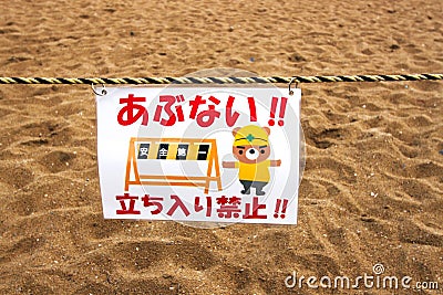 Kawai cute warning sign no trespassing at construction sight with sand pit featuring a Japanese calligraphy and a comic bear Editorial Stock Photo