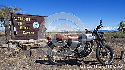 Kawasaki W175 motorbike with Welcome to Bekol Savana sign. Taman Nasional Baluran or Baluran National Park, Situbondo, East Java, Editorial Stock Photo