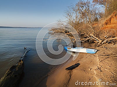 Kayak on the sandy beach with driftwood Stock Photo