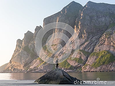 A kayaker stands on a rock at sunset on Bunes beach Stock Photo