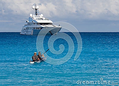 Kayakers on the kayak and a beautiful yacht in the background of clouds on the island of Kefalonia in the Ionian Sea in Greece Editorial Stock Photo