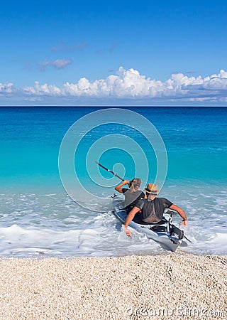 Kayakers on the kayak and a beautiful yacht in the background of clouds on the island of Kefalonia in the Ionian Sea in Greece Editorial Stock Photo