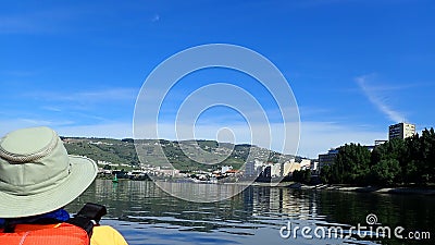 Kayaking in kayak on river with hills and plants and orange vest Stock Photo