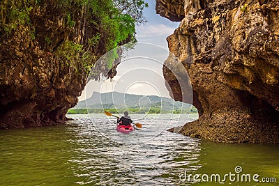 Kayaking under high cliffs in Thailand Stock Photo