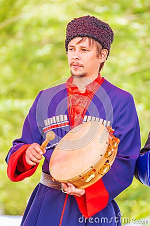 Kazak musician holds a tambourine in his hands and beats him with a beater Editorial Stock Photo