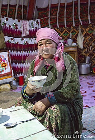 Kazak woman in Mongolia, drinking tea at her home yurt Editorial Stock Photo