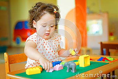 Kazakh curly girl playing in kids development center Stock Photo