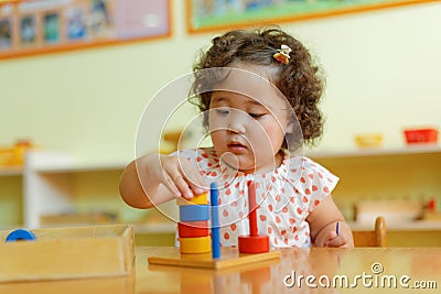 Kazakh curly girl playing in kids development center Stock Photo