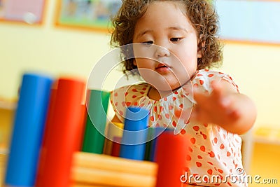 Kazakh curly girl playing in kids development center Stock Photo