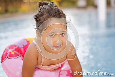 Kazakh little girl playing near swimming pool Stock Photo