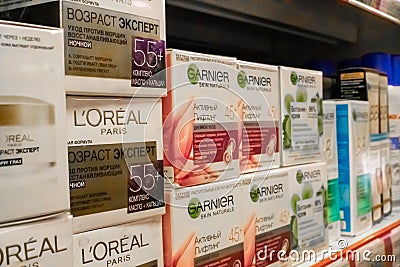 Loreal and garnier cosmetic products for sale on a supermarket shelf. Loreal and garnier brand for skin Editorial Stock Photo