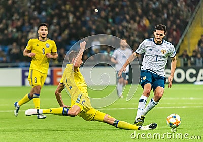 Kazakhstan national football team defender Serhiy Malyia in sliding tackle against Russia midfielder Magomed Ozdoyev Editorial Stock Photo