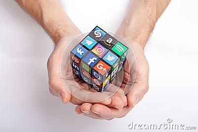 KAZAN, RUSSIA - January 27, 2018: Man`s hand holds a cube with collection of popular social media logos printed on adhesive paper Editorial Stock Photo