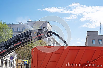 Asphalt milling machine fills dumptruck with old pavement Editorial Stock Photo