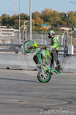 A biker rides on the back wheel of a bike Editorial Stock Photo