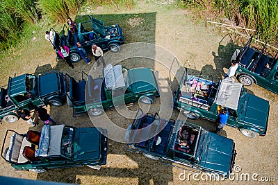 Kaziranga, Assam, India on 13 Nov 2014 - Aerial view of Tourists wating in Jeep for one horned big rhinoceros in the forests of K Editorial Stock Photo