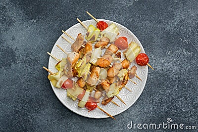 Kebab chicken, zucchini and tomatoes on skewers in a plate. Dark table Copy space Stock Photo