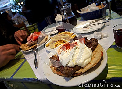 Kebab under Greek yoghurt on a pita - delicious food in a Greek tavern on a warm evening in Athens, Greece Stock Photo