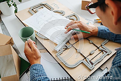 Keen box designer working on a blueprint, taking measures with a ruler Stock Photo