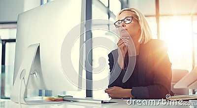 Keen business intuition. a thoughtful businesswoman working at her desk in a modern office. Stock Photo