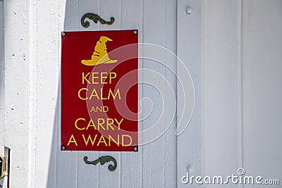 Keep calm and carry a wand gag humor sign hanging on wall Stock Photo