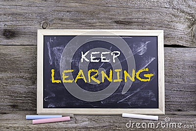 Keep Learning. Chalk board on a wooden table Stock Photo