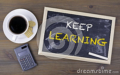 Keep Learning. Chalk board on a wooden table Stock Photo