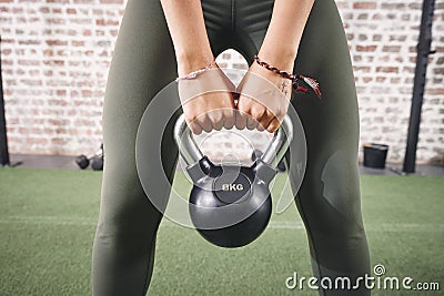 Keep in mind that your body is your slave, it works for you. a sporty young woman working out with a kettlebell at the Stock Photo