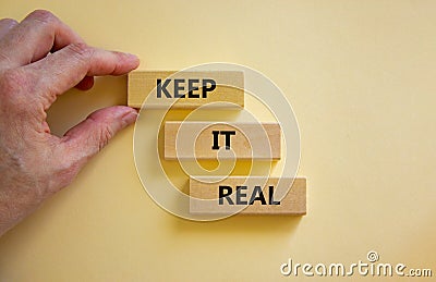 Keep it real symbol. Wooden blocks with words `keep it real` on beautiful white background. Businessman hand. Business, keep it Stock Photo