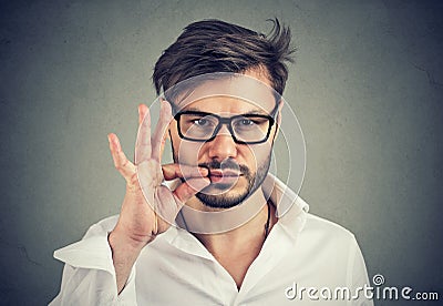 Keep a secret, man zipping his mouth shut. Quiet concept Stock Photo