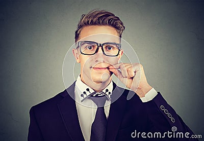 Keep a secret, young man zipping his mouth shut. Quiet concept Stock Photo