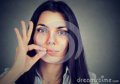 Keep a secret, woman zipping her mouth shut. Quiet concept Stock Photo