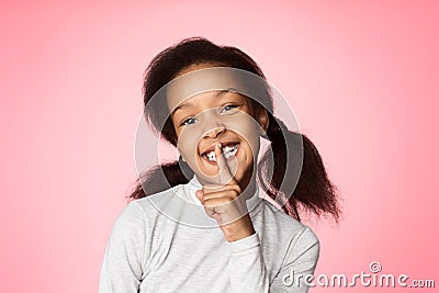 Keep silence. African-american girl holding finger on mouth Stock Photo