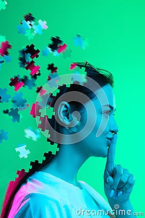 Creative collage. Side view portrait of young girl isolated over green background. Female head consist of puzzle pieces Stock Photo