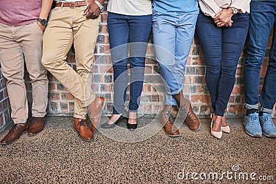 Keeping their feet firmly on the ground. Low angle shot of a group of creative coworkers legs as they stand in the Stock Photo