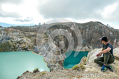 Kelimutu - A man admiring turquoise coloured volcanic lakes Stock Photo