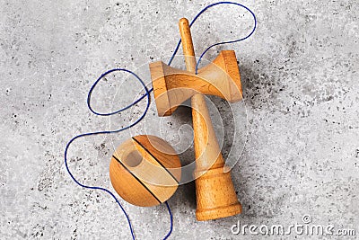 Kendama Japanese wooden toy with blue thread on a concrete background Stock Photo