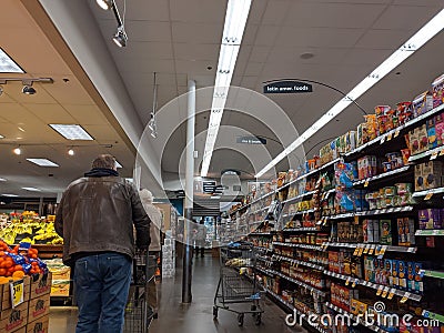 Kenmore, WA USA - circa March 2021: View of an elderly man shopping in the ethnic food aisle inside QFC Editorial Stock Photo