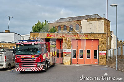 Kent Fire and Rescue Service building with orange doors, red fire truck in front Editorial Stock Photo