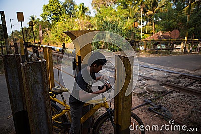 Indian boy on a Bicycle crosses the railway. Editorial Stock Photo