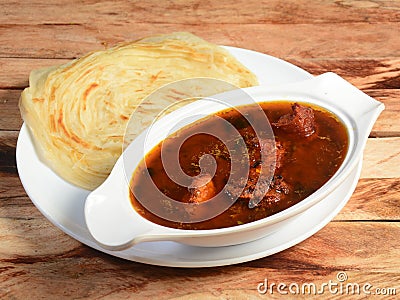 Kerala paratha / parotta, layered flat bread made from maida or whole wheat flour. Served with spicy kerala chicken curry, Stock Photo